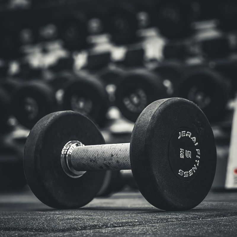 Detail of a man's hands gripping a heavy dumbbell